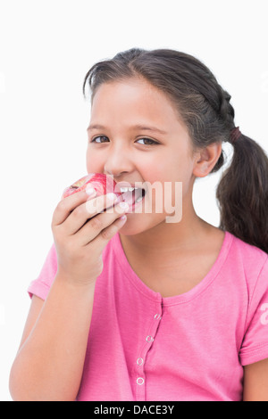 Kleine Mädchen essen Apfel lächelnd Stockfoto