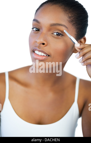 Junge Frau, die ihre Pinzette Stockfoto