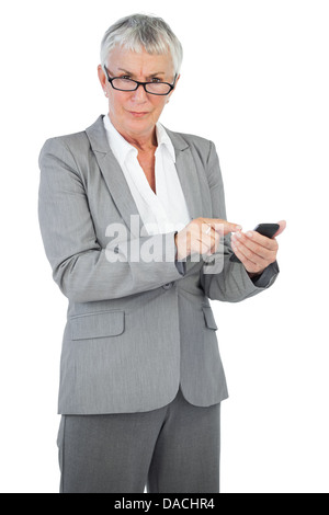 Geschäftsfrau mit einer Brille, die mit ihrem Mobiltelefon Stockfoto