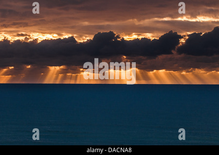 Sonnenstrahlen durchscheinen Wolken bei Sonnenaufgang, Moreton Island, Queensland, Australien Stockfoto