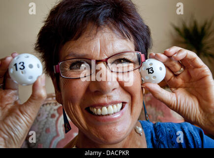 Deutschlands erste Lotto-Fee, Elvira Hahn, hält zwei Pfingstmontag Kugeln mit der Zahl 13 in Erzhausen, Deutschland, 30. September 2011. Sie war derjenige, der die Zahlen der ersten Zeichnung am 9. Oktober 1955 in Hamburg zog. Damals war sie zwölf Jahre alt und lebte in einem Waisenhaus. Sie zog zunächst die 13. Foto: FRANK RUMPENHORST Stockfoto