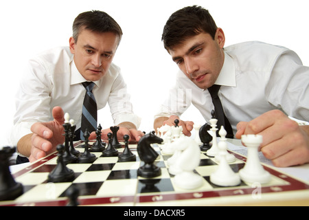 Isolierte Bild von ernsthaften Geschäftsleuten ihr strategische Denken zu entwickeln, spielt Schach Stockfoto