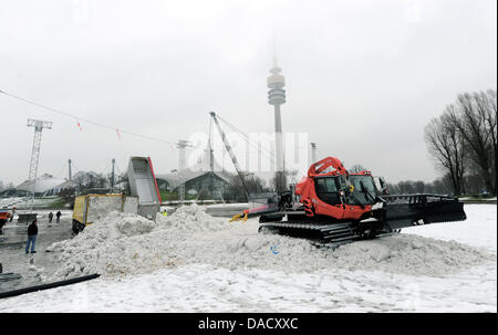 LKW (L) entladen Schnee im Zielgelände für die Ski-WM im Olympiapark in München, 22. Dezember 2011. Der FIS World Cup wird am Olympiapark in München am 1. Januar 2011 stattfinden. Schnee wird von Orten, einschließlich Flughafen München geliefert werden, aber das Ereignis in der Schwebe aufgrund widriger Witterungsbedingungen hängt. Foto: TOBIAS HASE Stockfoto