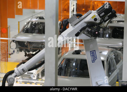 Ein Roboter arbeitet im Volkswagen-Werk in Nanjing in der Nähe von Shanghai, China, 26. November 2011. Auf der Rückseite sind Körper einer Passat Limousine für den chinesischen Markt gesehen. Das Lackieren von Autos, die in China produziert werden läuft mit Technik des deutschen Automobilherstellers der Produkte Duerr. Die Duerr-Gruppe gewinnt den größten Teil seines Gewinns und die eingehenden Aufträge in China. Foto: Heiko Lo Stockfoto