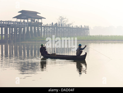 Fischer am Taungthaman-See in der Morgendämmerung mit U Bein Brücke, Amarapura, in der Nähe von Mandalay, Myanmar Stockfoto