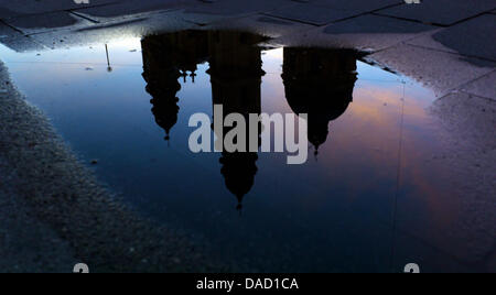 Die Kuppel und die Kirchtürme der Theatine Kirche des St. Cajetan sind Relfected in einer Pfütze von Regenwasser in der Abenddämmerung auf dem Odeon-Platz in München, Deutschland, 8. Dezember 2011. Foto: Peter Kneffel Stockfoto