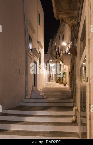 Gasse und Schritte zwischen den weiß getünchten Häusern in der Nacht im historischen Zentrum von Hügel Stadt Ostuni, Apulien, Süditalien Stockfoto