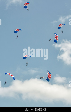 Fallschirmspringer aus der Royal Air Force Falcons anzeigen Team füllen den Himmel mit ihren bunten Fallschirm Verdecke in RAF Waddington Stockfoto