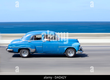 Verrissen Schuss Blau von alten amerikanischen Autos, Karibische Meer im Hintergrund, der Malecon, West Indies, Kuba, Havanna Centro Stockfoto