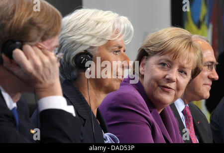 Weltbank-Präsident Robert Zoellick (L-R), Präsident des IWF Christine Lagarde, deutsche Bundeskanzlerin Angela Merkel (CDU) und OECD-Generalsekretär Angel Gurría Platz genommen haben einen Anfang einer Pressekonferenz in Berlin, Deutschland, 6. Oktober 2011. Merkel war mit Finanz-Experten zu Fragen rund um das Währungssystem konferieren. Foto: MICHAEL KAPPELER Stockfoto