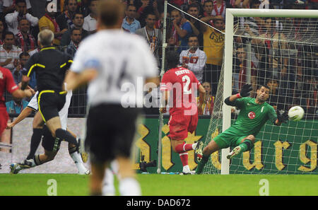 Deutschlands Mario Gomez versteckt () Partituren, die das 1: 0 gegen Torhüter Volkan Demirel (R) der Türkei um die Kugel während der EURO 2012-Qualifikationsspiel zwischen der Türkei und Deutschland in der Turk Telekom Arena in Istanbul, Türkei 7. Oktober 2011 wetteifern. Foto: Hannibal Dpa +++(c) Dpa - Bildfunk +++ Stockfoto