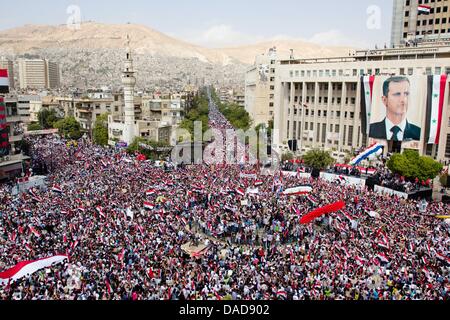 Tausende von Syrer Welle Nationalflaggen sowie chinesische und russische Fahnen während einer regierungsnahen Kundgebung auf Saba Bahrat Platz in Damaskus, Syrien, am 12. Oktober 2011. Laut Medienquellen sammelten sich Tausende von Syrer zur Unterstützung des Regimes des syrischen Präsidenten Bashar al-Assad, und Anerkennung nach Russland und China für ihre unterstützende Haltung für Syrien. Am 04 Oktober Stockfoto