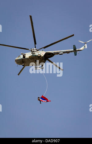 Ein Hubschrauber mit der syrischen Flagge schwebt über Tausende Syrer während einer regierungsnahen Kundgebung am Saba Bahrat Platz in Damaskus, Syrien, am 12. Oktober 2011. Laut Medienquellen sammelten sich Tausende von Syrer zur Unterstützung des Regimes des syrischen Präsidenten Bashar al-Assad, und Anerkennung nach Russland und China für ihre unterstützende Haltung für Syrien. Am 04 Oktober, Russland ein Stockfoto