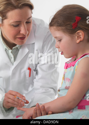 Allgemeinmedizin Arzt impfen ein kleines Mädchen in der Chirurgie Stockfoto