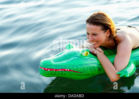 Frau im Meer mit aufblasbaren Krokodil Stockfoto