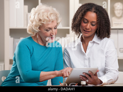 Zwei Frauen, die mit digital-Tablette Stockfoto