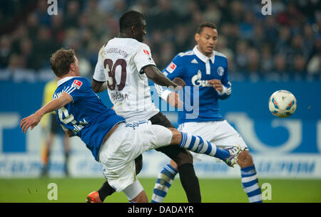 Schalke Benedikt Höwedes (L) und Jermaine Jones (R) wetteifern um den Ball mit Kaiserslautern Dorge Kouemaha während der Bundesliga-Fußball-Spiel zwischen FC Schalke 04 und 1. FC Kaiserslautern in der Veltins Arena in Gelsenkirchen, Deutschland, 15. Oktober 2011. Foto: Bernd Thissen Stockfoto