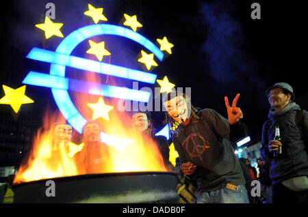 Demonstranten, die Masken tragen 'Guy Fawkes' stehen neben einem Feuer vor der Europäischen Zentralbank in Frankfurt Main, Deutschland, 15. Oktober 2011. Mehrere tausend Menschen protestieren gegen die Macht der Finanzmärkte. Die Bewegung Modelle selbst auf die amerikanische "Occupy Wall Street"-Proteste. Foto: Arne Dedert Stockfoto