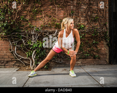 Junge Frau stretching vor dem Training Stockfoto