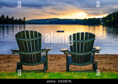 Zwei hölzerne Stühle am Strand von entspannenden See bei Sonnenuntergang. Algonquin provincial Park, Kanada. Stockfoto