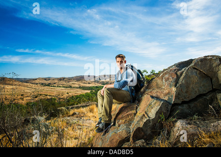 Männliche Wanderer auf Felsen sitzend Stockfoto
