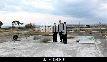 German President Christian Wulff (C) besucht die Küstenstadt Toyoma und sieht sich die Schäden, die durch die Tsunami-Katastrophe in der Präfektur Fukushima, Japan, 25. Oktober 2011. Auf der linken Seite japanischer Botschafter in Deutschland, Takahiro Shinyo gesehen wird, ist auf der rechten Seite, der Präfekt der Region, Yuhei Sato, gesehen. Das deutsche Staatsoberhaupt ist in Japan für eine sechs-Tage Staatsbesuch. Foto: WOL Stockfoto