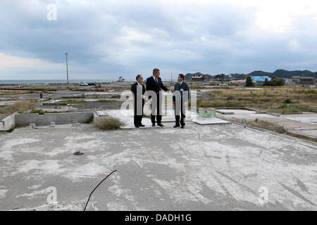 German President Christian Wulff (C) besucht die Küstenstadt Toyoma und sieht sich die Schäden, die durch die Tsunami-Katastrophe in der Präfektur Fukushima, Japan, 25. Oktober 2011. Auf der linken Seite japanischer Botschafter in Deutschland, Takahiro Shinyo gesehen wird, ist auf der rechten Seite, der Präfekt der Region, Yuhei Sato, gesehen. Das deutsche Staatsoberhaupt ist in Japan für eine sechs-Tage Staatsbesuch. Foto: WOL Stockfoto