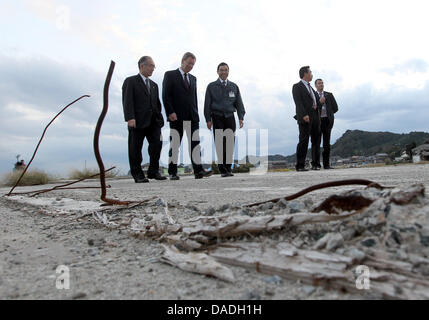 German President Christian Wulff (C) besucht die Küstenstadt Toyoma und sieht sich die Schäden, die durch die Tsunami-Katastrophe in der Präfektur Fukushima, Japan, 25. Oktober 2011. Nach dem Präsidenten links japanischer Botschafter in Deutschland, Takahiro Shinyo gesehen wird, ist an des Präsidenten direkt, der Präfekt der Region, Yuhei Sato, gesehen. Die Menschen auf der rechten Seite sind nicht identifiziert. Die Ge Stockfoto