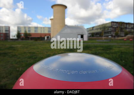 Ein rotes elliptisches Objekt, das die Soundinstallation Luft getragen gehört befindet sich vor einer Motor-Prüfstand an der Aerodynamik-Park auf dem Campus der Humboldt-Universität Berlin in Berlin-Adlershof, Deutschland, 13. Oktober 2011. Der Motor-Prüfstand für wissenschaftliche Zwecke in den 1930er Jahren errichtet und ist heute ein Denkmal, die Besucher über die Geschichte der erinnern soll die Stockfoto