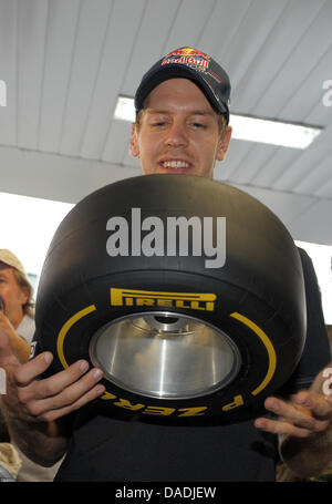 Deutsche Formel1-Fahrer Sebastian Vettel von Red Bull halten einen Mini Pirelli Slick an der Rennstrecke Buddh International Circuit, Greater Noida, Indien, 27. Oktober 2011. Die erste Formel 1 Grand Prix von Indien statt findet am 30. Oktober 2011. Foto: David Ebener Dpa +++(c) Dpa - Bildfunk +++ Stockfoto