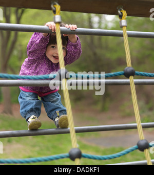 Junges Mädchen auf dem Klettergerüst auf Spielplatz, Porträt Stockfoto
