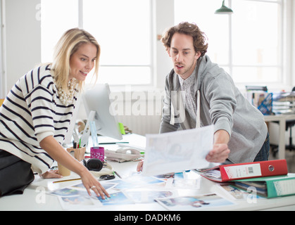 Junge Kolleginnen und Kollegen diskutieren Fotografien treffen in Kreativbüro Stockfoto