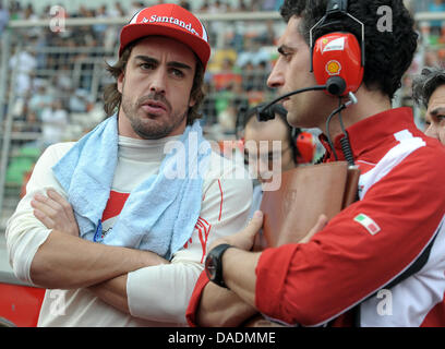 Spanische Formel1-Fahrer Fernando Alonso (L) von Ferrari spricht mit seinen Ingenieuren im Raster kurz vor dem Start des Rennens auf dem Buddh International Circuit, Greater Noida, Indien, 30. Oktober 2011. Die erste Formel 1 Grand Prix von Indien statt findet am 30. Oktober 2011. Foto: David Ebener Dpa +++(c) Dpa - Bildfunk +++ Stockfoto