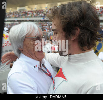 F1-Boss Bernie Ecclestone (L) und spanischen Formel-1 Fahrer Fernando Alonso Ferrari Umarmung im Raster kurz vor dem Start des Rennens auf dem Buddh International Circuit, Greater Noida, Indien, 30. Oktober 2011. Foto: David Ebener dpa Stockfoto