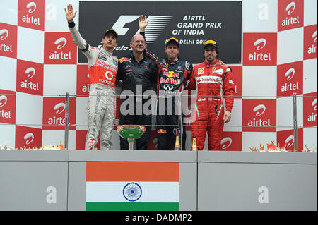 Deutsche Formel1-Fahrer Sebastian Vettel von Red Bull zu gewinnen (2. L) zweite britische Jenson Button (L) von McLaren Mercedes dritte Spanisch Fernando Alonso (R) von Ferrari und Adrian Newey, Leiter technische Directoron das Podium beim Rennen verfolgen Buddh International Circuit, Großraum Noida, Indien, 30. Oktober 2011. Vettel gewann das erste Formel 1 Grand Prix von Indien. Foto: David E Stockfoto