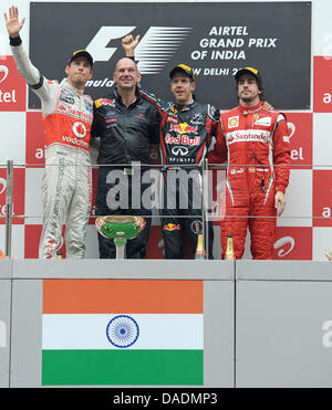 Deutsche Formel1-Fahrer Sebastian Vettel von Red Bull zu gewinnen (2. L) zweite britische Jenson Button (L) von McLaren Mercedes dritte Spanisch Fernando Alonso (R) von Ferrari und Adrian Newey, Leiter technische Directoron das Podium beim Rennen verfolgen Buddh International Circuit, Großraum Noida, Indien, 30. Oktober 2011. Vettel gewann das erste Formel 1 Grand Prix von Indien. Foto: David E Stockfoto