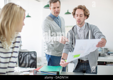Junger Mann zeigt Pläne Kollegen treffen in Kreativbüro Stockfoto