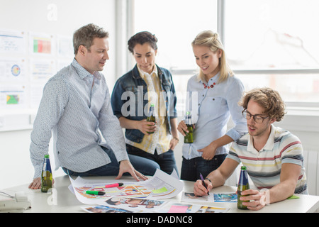Bürokollegen diskutieren kreative Pläne auf Schreibtisch Stockfoto