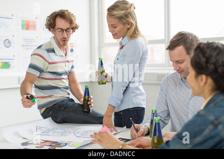 Bürokollegen diskutieren kreative Pläne auf Schreibtisch Stockfoto