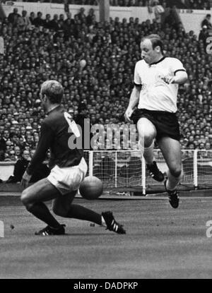 (Dpa-Datei) - ein Datei-Bild vom 30. Juli 1966 zeigt deutscher Fußballspieler Uwe Seeler (R) wetteifern um den Ball mit Engländer Bobby Moore im Wembley-Stadion in London, Großbritannien. Uwe Seeler wird am 5. November 2011 75. Foto: Dpa Stockfoto