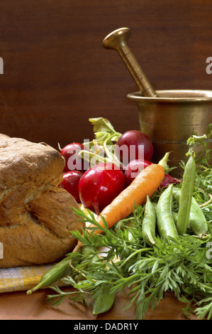 Leckeres frisches Gemüse und knusprige hausgemachte Brot mit alten Bronze Mörser. Stockfoto