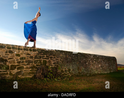 Tänzerin, balanciert auf Steinmauer Stockfoto