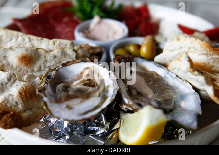 Eine Platte mit regionalen Austern, Meeresfrüchte und Fleischgerichte serviert in Antwerpen, Belgien.