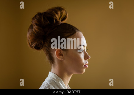 Porträt einer jungen Frau mit ihrem Haar in einem Brötchen hautnah Stockfoto