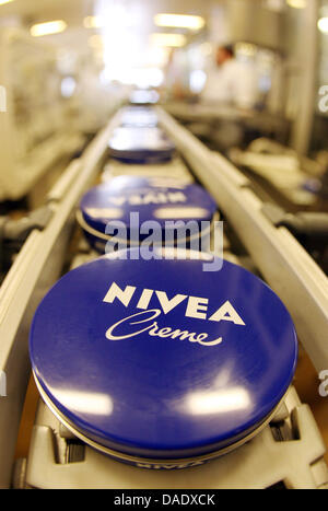 (Dpa-Datei) - eine Datei Buchsten vom 18. Dezember 2006 zeigt blaue NIVEA Creme Dosen am Fließband in der Produktionsstätte der Firma Beiersdorf in Hamburg, Deutschland. Beiersdorf gibt eine Pressekonferenz über die finanziellen Ergebnisse der letzten neun Monate in Hamburg am 3. November 2011. Foto: Kay Nietfeld Stockfoto