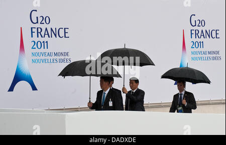 Mitglieder der Delegationen kommen auf dem G20-Gipfel bei strömendem Regen in Cannes, Frankreich, 4. November 2011. Am 03 und 4. November 2011 treffen sich die Staatschefs von den führenden Volkswirtschaften der Welt (G20) zum diesjährigen Gipfel. Foto: PEER GRIMM Stockfoto