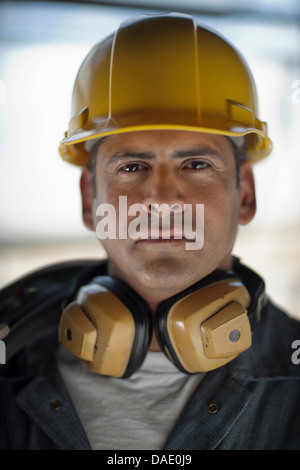 Reife Bauarbeiter tragen harter Hut und Ohr Verteidiger Stockfoto