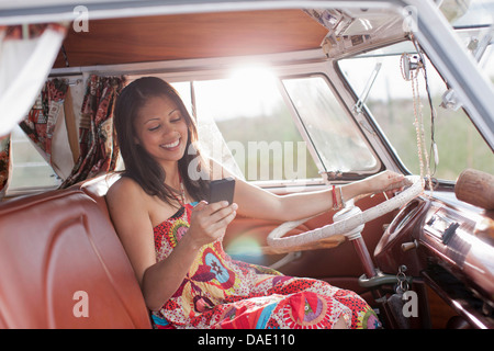 Junge Frau mit Handy im Wohnmobil Stockfoto