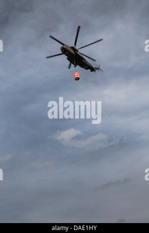 Deutschland, Laupheim, deutsche CH-53 Hubschrauber fliegen in der Luft mit Wasser-Eimer Stockfoto