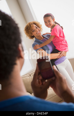 Vater nehmen Foto von Mutter und Tochter auf Kamera-Handy Stockfoto